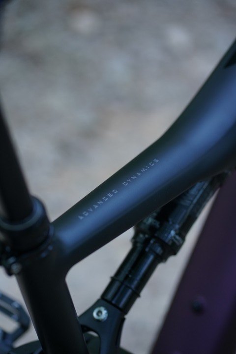 Schwarzes Oberrohr mit mattem Finish, elegant geschwungen am violetten Rahmen.